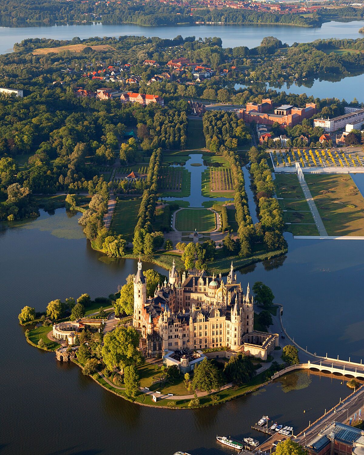 Das Schloss Schwerin mit seinen vielen Türmen und dem umgebenden See von oben.