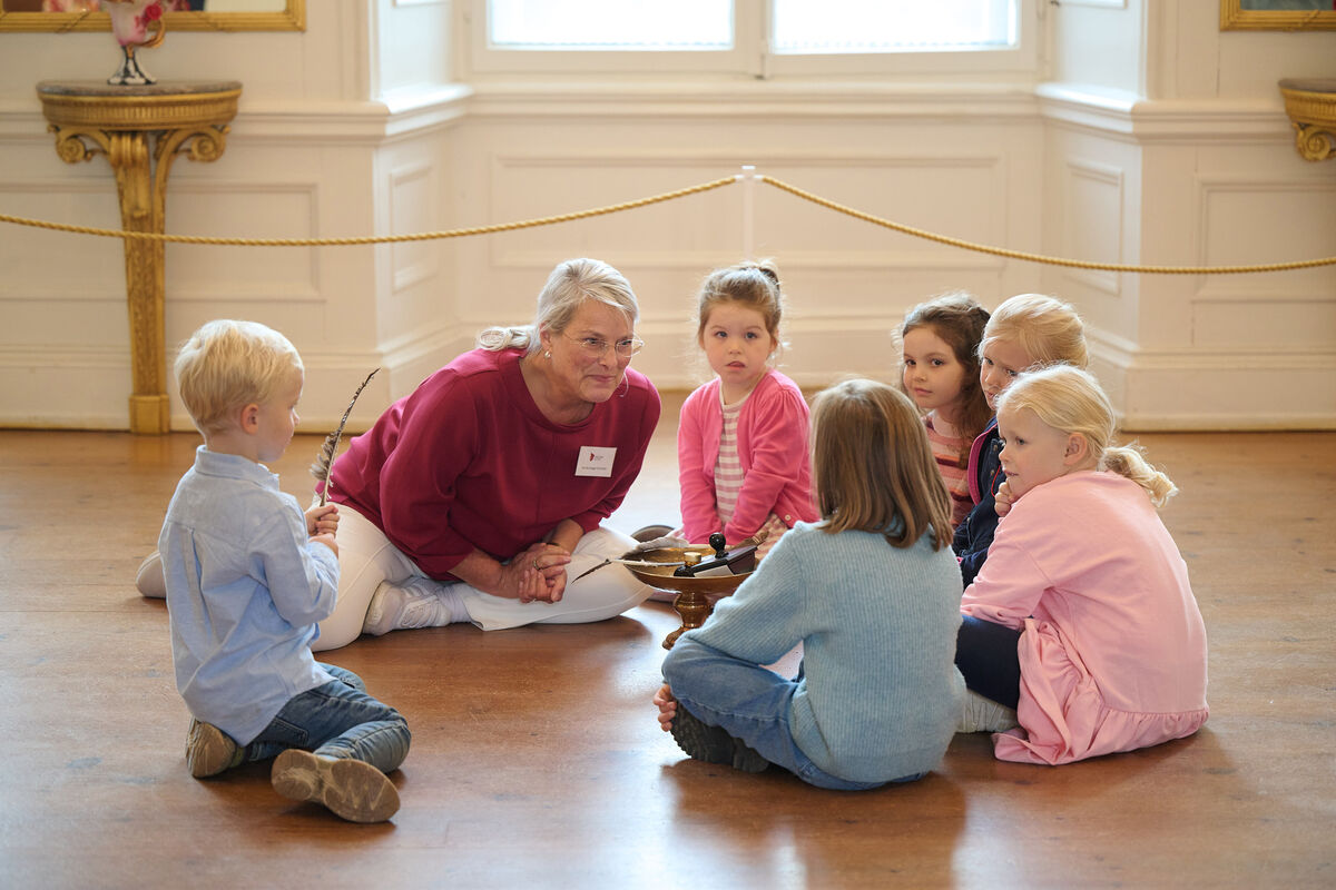 Eine Museumsführerin erzählt Kindern vom einstigen Leben im Schloss mit einer Geschichte.